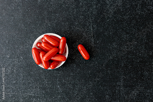 ubiquinol supplement softgels on black background. mental wellbeing and personal health concept photo