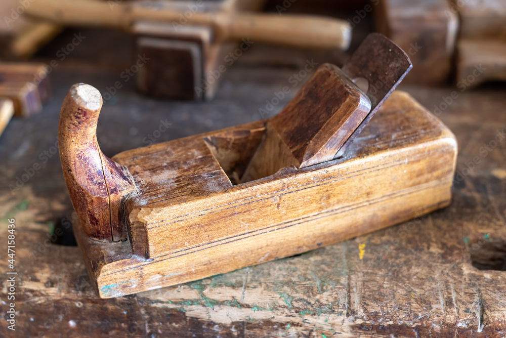 An old wooden plane on a workbench, shallow depth of field. An old wooden plane on a workbench, shallow depth of field.