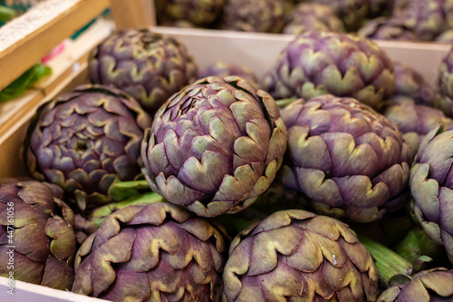 New harvest of French violet globe artichokes on weekly market in Provence, France