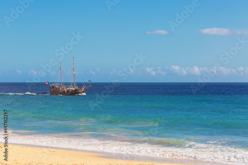 Pleasure tourist ship near the famous beach of Praia dos Caneiros.