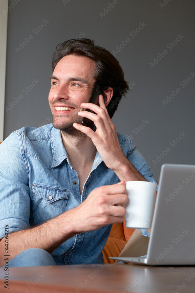 Single male sitting at home, drinking his coffee and doing his online jobs Single male sitting at home, drinking his coffee and doing his online jobs