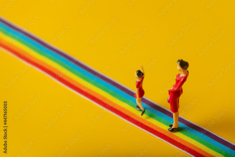 little mother and daughter figures on the LGBT rainbow path