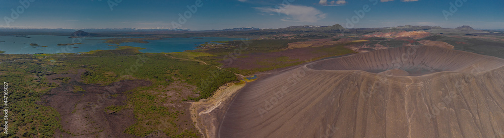 Hverfjall crater as seen from the air in a aerial drone panorama picture. Dry crater in Iceland during hot summer days. Lake Myvatn to the left. Hverfjall crater as seen from the air in a aerial drone panorama picture. Dry crater in Iceland during hot summer days. Lake Myvatn to the left.