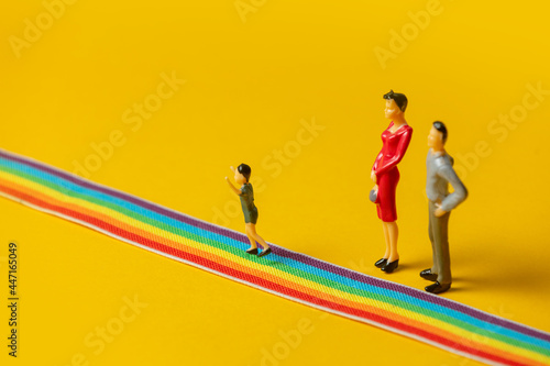 little parents and son figures on the LGBT rainbow path