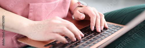 Female hands typing on laptop keyboard closeup