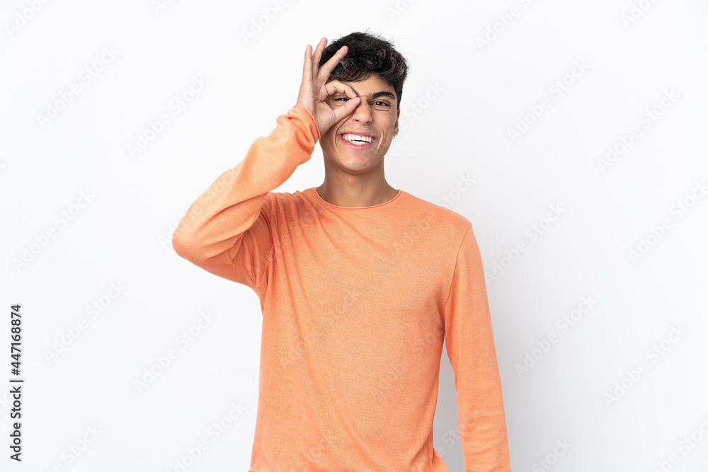 Young man over isolated white background showing ok sign with fingers Young man over isolated white background showing ok sign with fingers