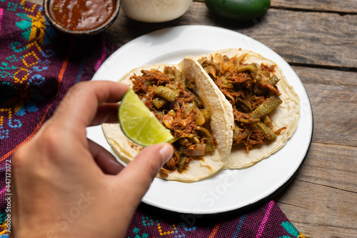 Mexican food. Chilorio and nopales tacos on wooden background photo