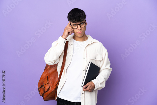Young student man over isolated purple background thinking an idea © luismolinero