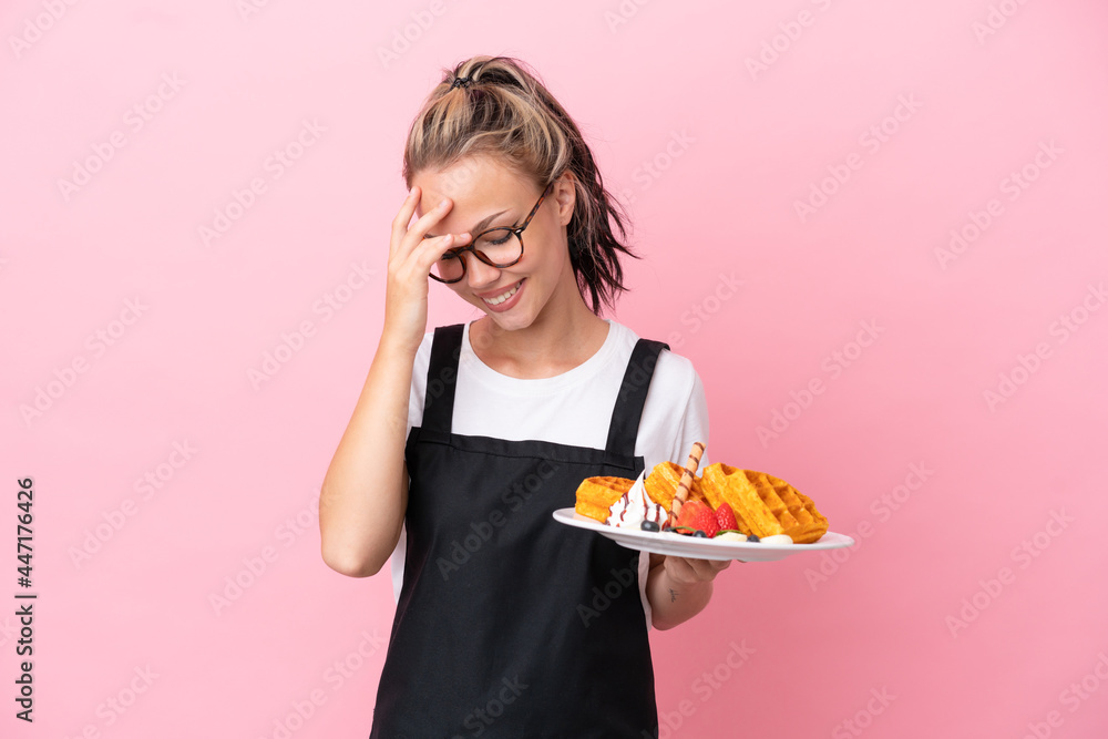 Restaurant waiter Russian girl holding waffles isolated on pink background laughing Restaurant waiter Russian girl holding waffles isolated on pink background laughing