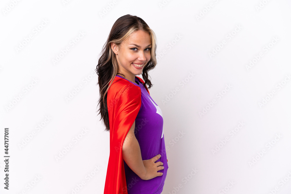 Teenager Russian girl isolated on white background in superhero costume and doingposing with arms at hip and smiling Teenager Russian girl isolated on white background in superhero costume and doingposing with arms at hip and smiling