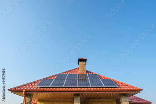 Solar panels on the roof of a private house on blue sky background photo