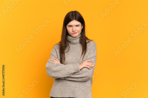 Young Ukrainian girl isolated on yellow background with unhappy expression © luismolinero
