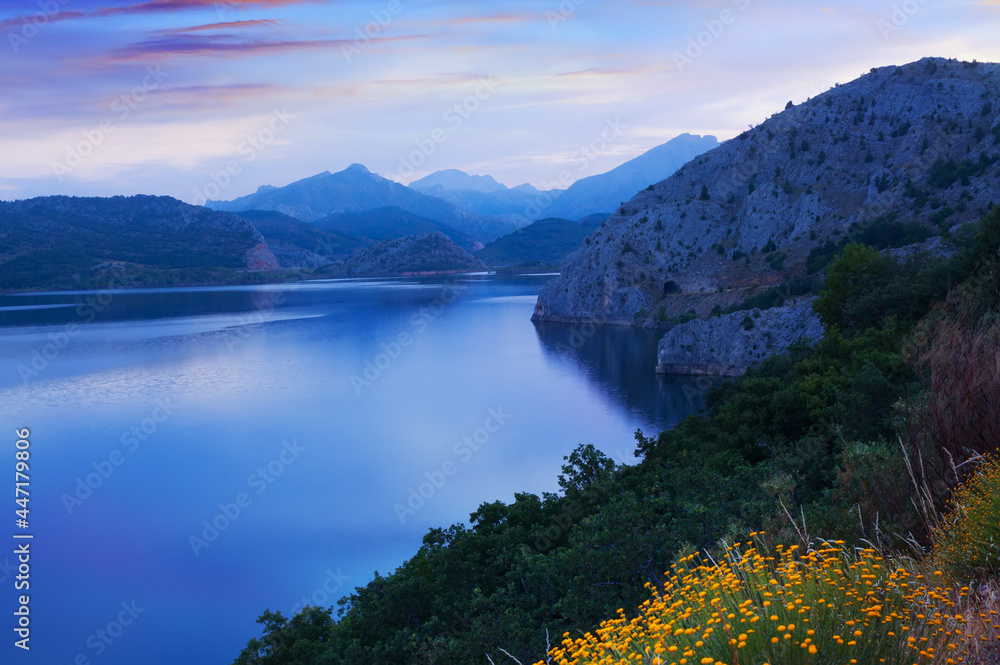 Summer mountains landscape with lake in twilight time. Barrios de Luna reservoir in Leon, Spain