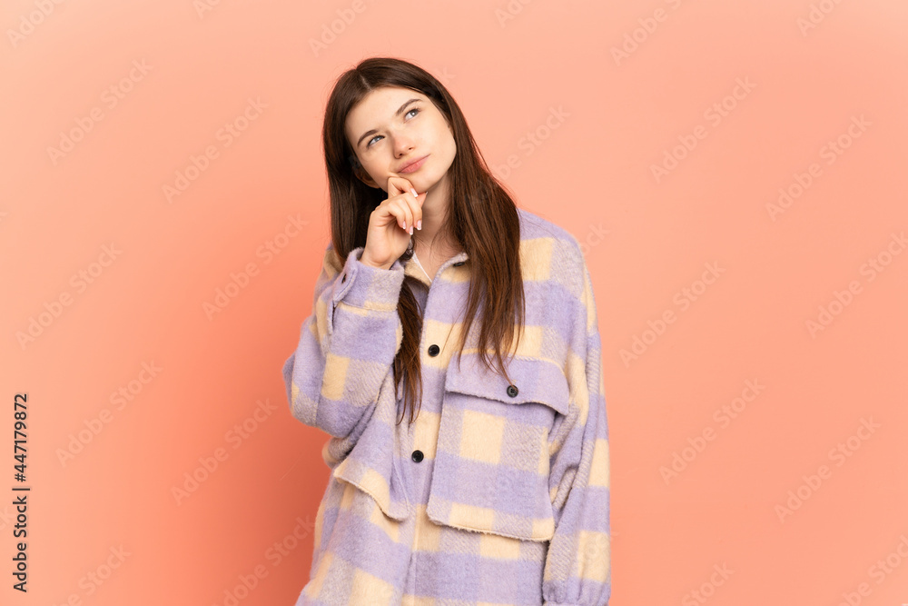 Young Ukrainian girl isolated on pink background and looking up Young Ukrainian girl isolated on pink background and looking up