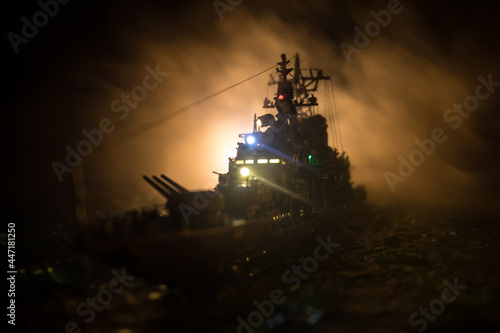 Silhouettes of a crowd standing at blurred military war ship on foggy background. Selective focus. © zef art