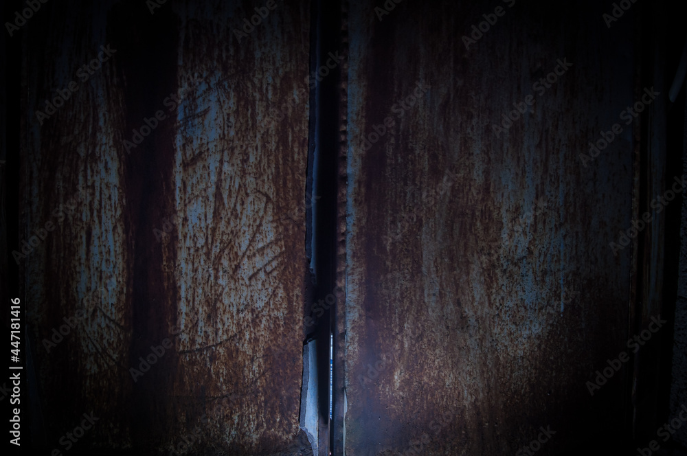 old rusty metal background or texture in dark room with light. Close up. old rusty metal background or texture in dark room with light. Close up.
