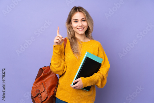 Teenager Russian student girl isolated on purple background pointing up a great idea