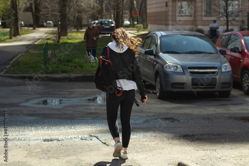 The girl is walking along the road. The woman walks through the city.