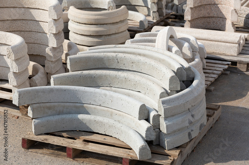 Lots of curbstones packed in stacks are stored on ground outdoors at a hardware store warehouse photo