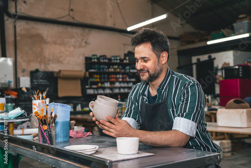 young adult potter with his pottery pieces