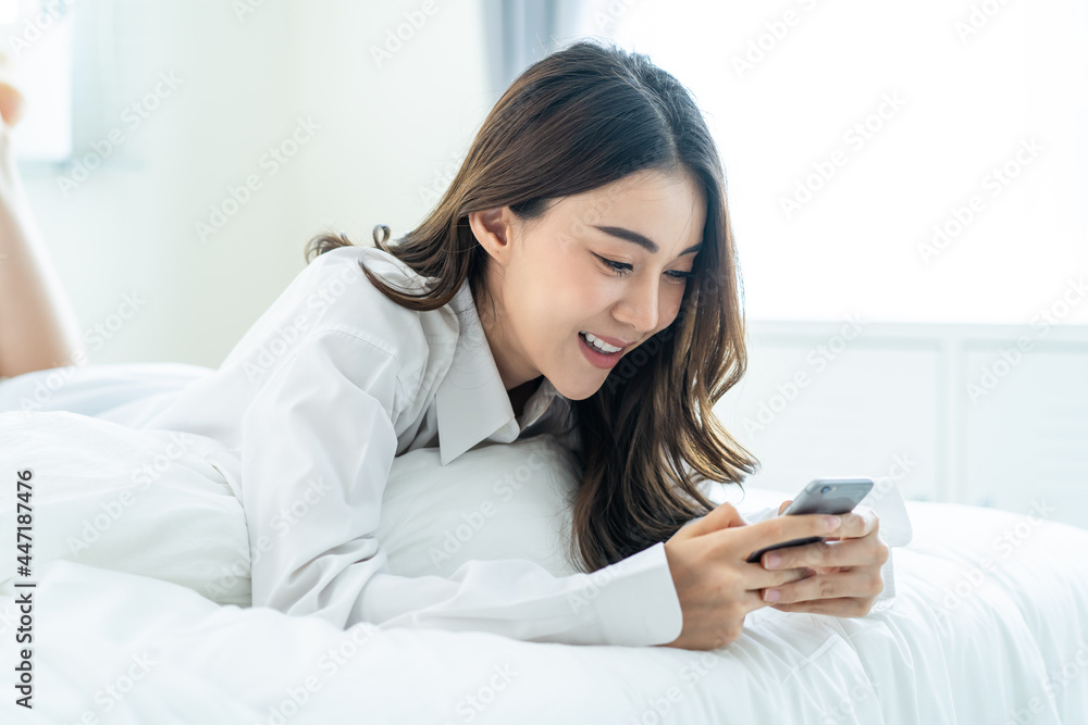 Asian attractive woman use mobile phone chat on bed at home in morning Asian attractive woman use mobile phone chat on bed at home in morning