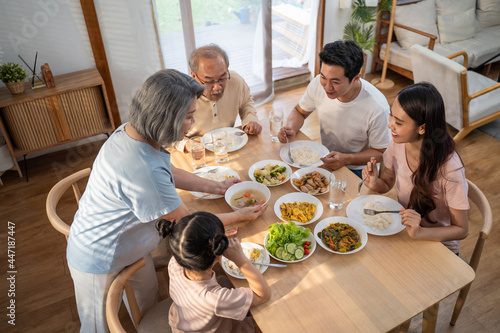 Foto Asian Big happy family spend time have lunch on dinner table together