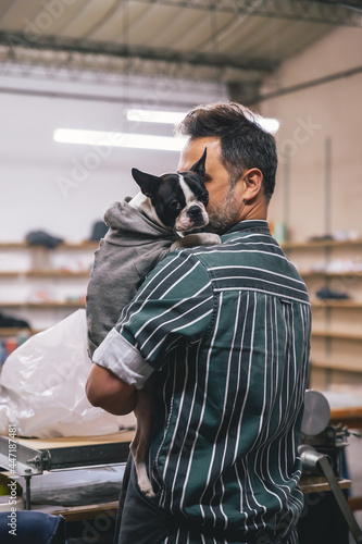 adult man holding a French bulldog breed dog