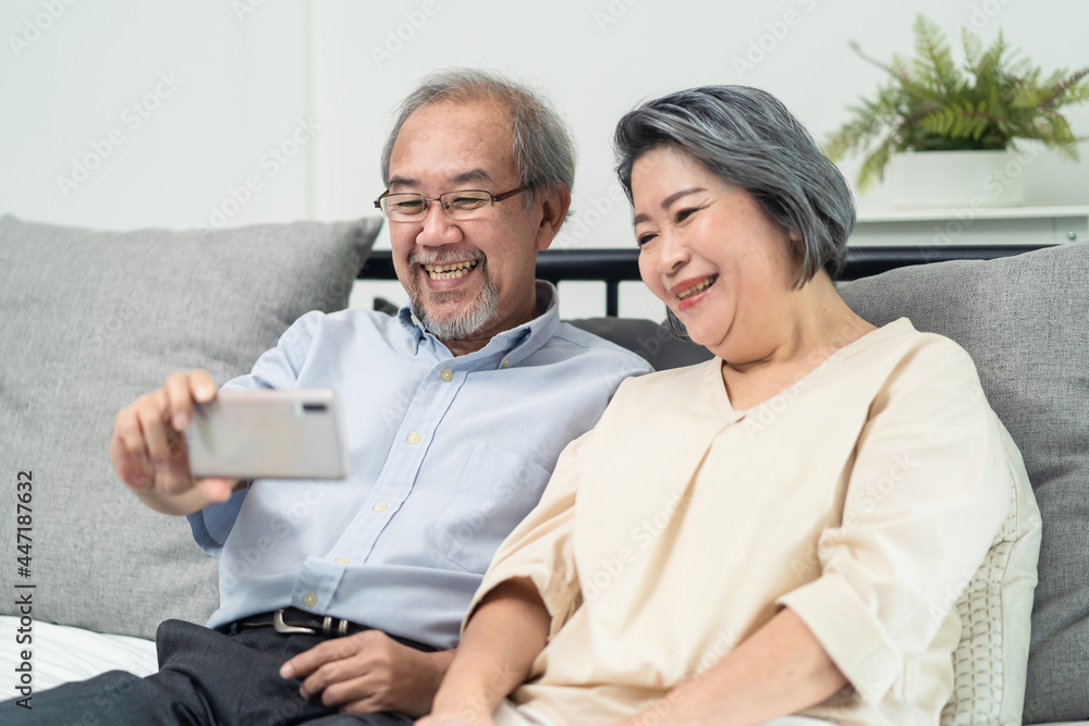 Asian senior elderly couple use phone remote video call with family. 