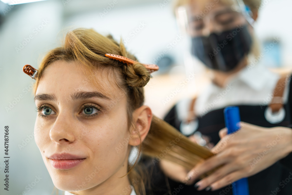 Fototapeta premium Asian hairdresser wear mask, cutting hair of beautiful woman in salon.