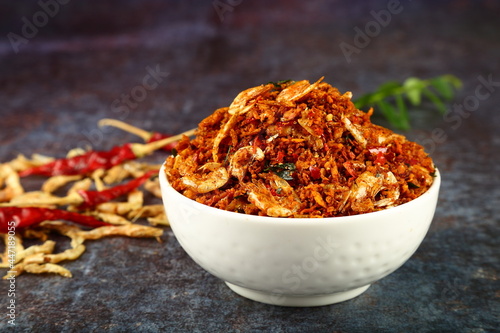 Homemade spicy dry fish chutney with coconut and spices- Kerala foods background.