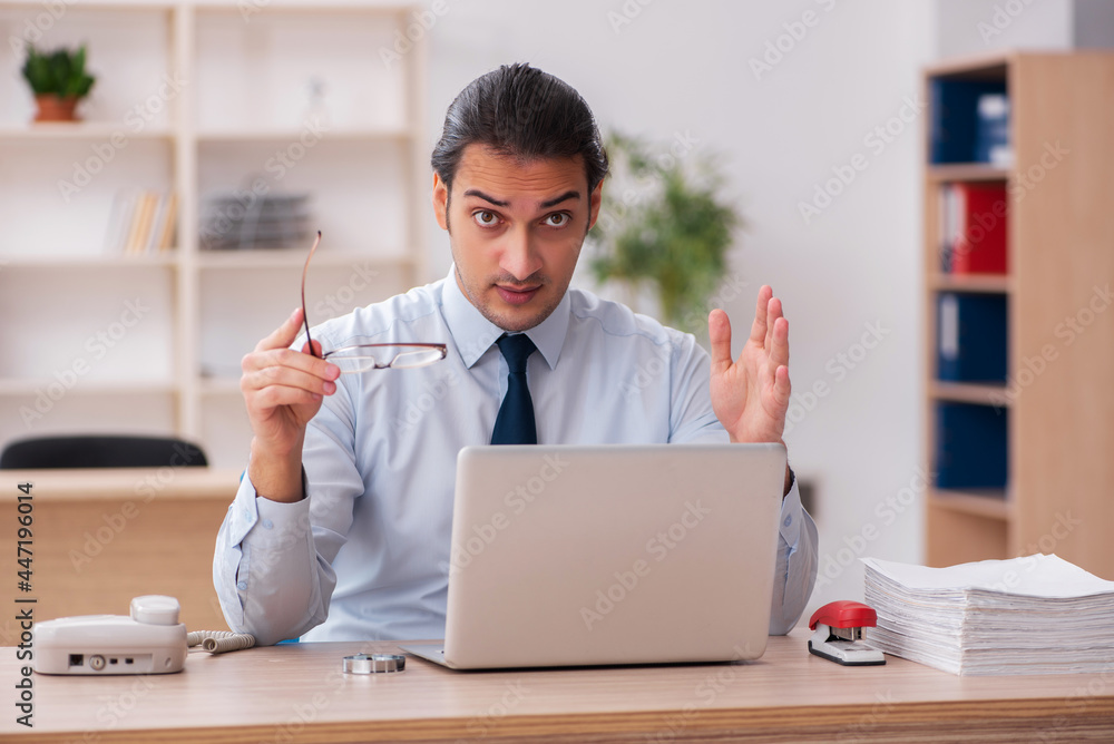 Young male employee working in the office Young male employee working in the office