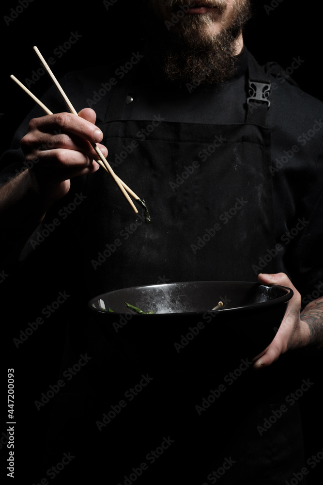 Chef holding a bowl with freshly made soup Chef holding a bowl with freshly made soup