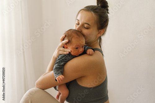 Papier peint Mother holds and hugs her newborn baby son at home