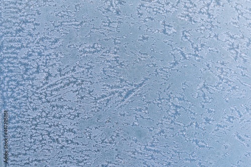 Selective focus. First frost on a frozen car, late autumn close-up. Beautiful abstract frozen microcosmos pattern. Freezing weather frost action in nature. Winter backdrop.