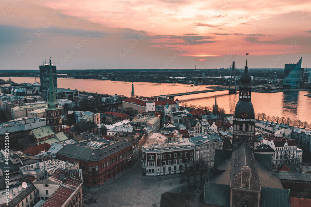 RIga rooftop view panorama at sunset with urban architectures and Daugava River. - obrazy, fototapety, plakaty 