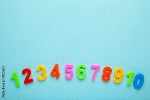 Magnetic multi-coloured figures on blue background with copy space. Back to school.