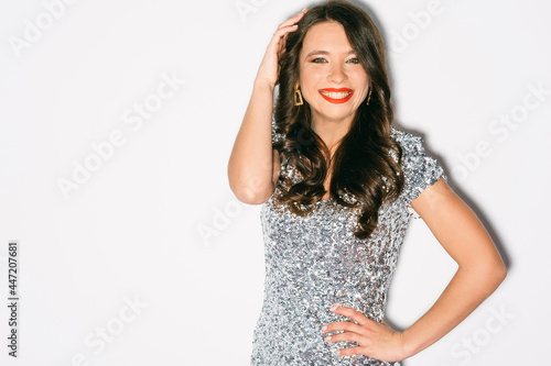 Enjoying party. Excited woman. Festive celebration. Holiday mood. Pretty happy lady sparkle silver dress posing on camera isolated white copy space.
