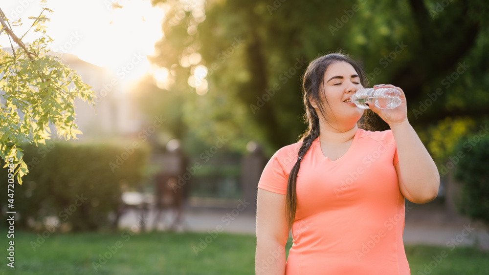 Thirst reduce. Healthy well-being. Weight loss improve. Body positive. Satisfied young obese overweight woman drinking water in defocused empty space summer park.