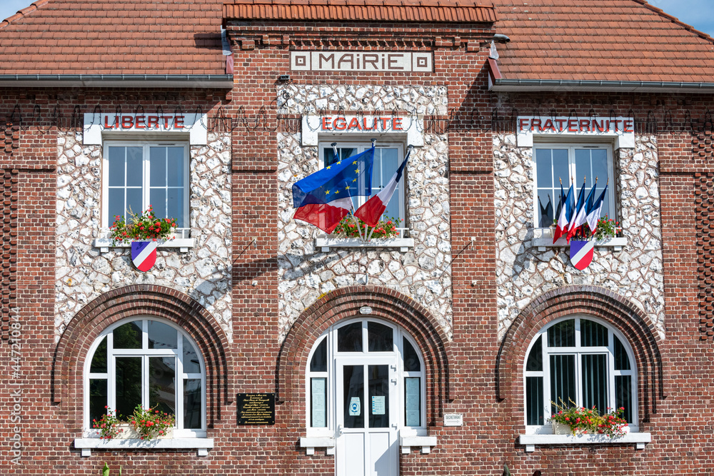 Obraz premium Facade d'une mairie avec drapeaux français bleu blanc rouge et européen, à l'occasion de la fête nationale du 14 juillet. Devise sur la facade : Liberté, Egalité, Fraternité