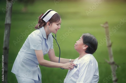 Beautiful and kindly hearted female volunteer nurses help to check the health and take care of the elderly and children in the local village