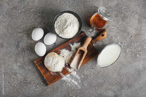 Ingredients for preparing bakery and utensils on grey background