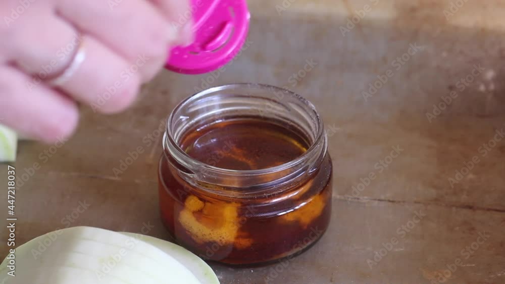 The woman chops the garlic and adds it to the olive oil. Nearby, sliced zucchini on a tray for baking. Close-up shot.. The woman chops the garlic and adds it to the olive oil. Nearby, sliced zucchini on a tray for baking. Close-up shot..