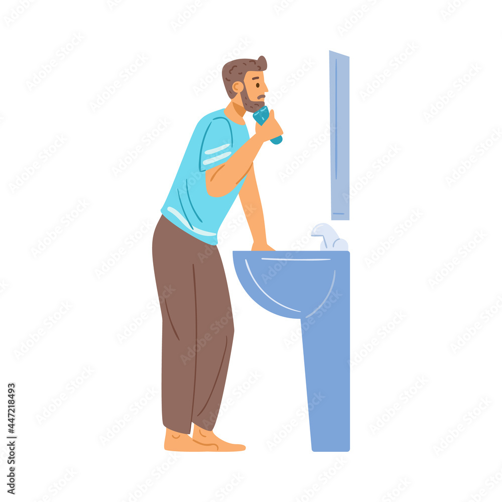 Young man shave beard on face with electric razor in front of mirror in bathroom Young man shave beard on face with electric razor in front of mirror in bathroom
