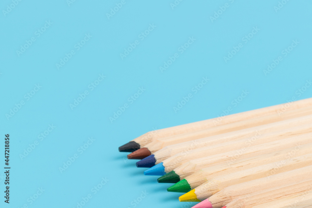 Obraz premium Wooden colorful ordinary pencils isolated on blue background. Back to school