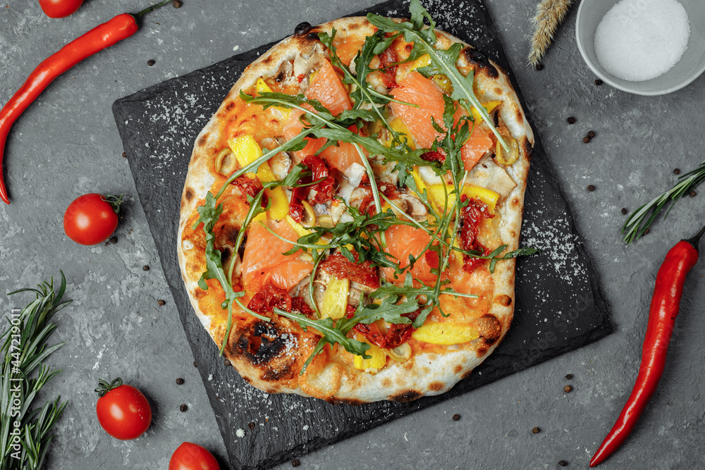 Delicious pizza with salmon and vegetables. italian pizza