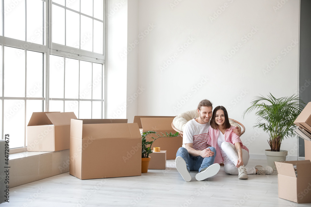 Young couple with cardboard boxes in their new house on moving day Young couple with cardboard boxes in their new house on moving day