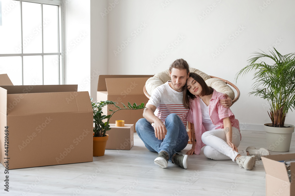 Young couple with cardboard boxes in their new house on moving day Young couple with cardboard boxes in their new house on moving day