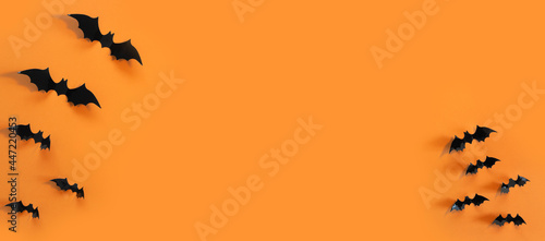 Halloween card with black bats on orange background. Banner for congratulations or invitation.