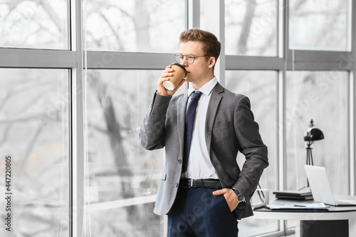 Young man drinking coffee in office