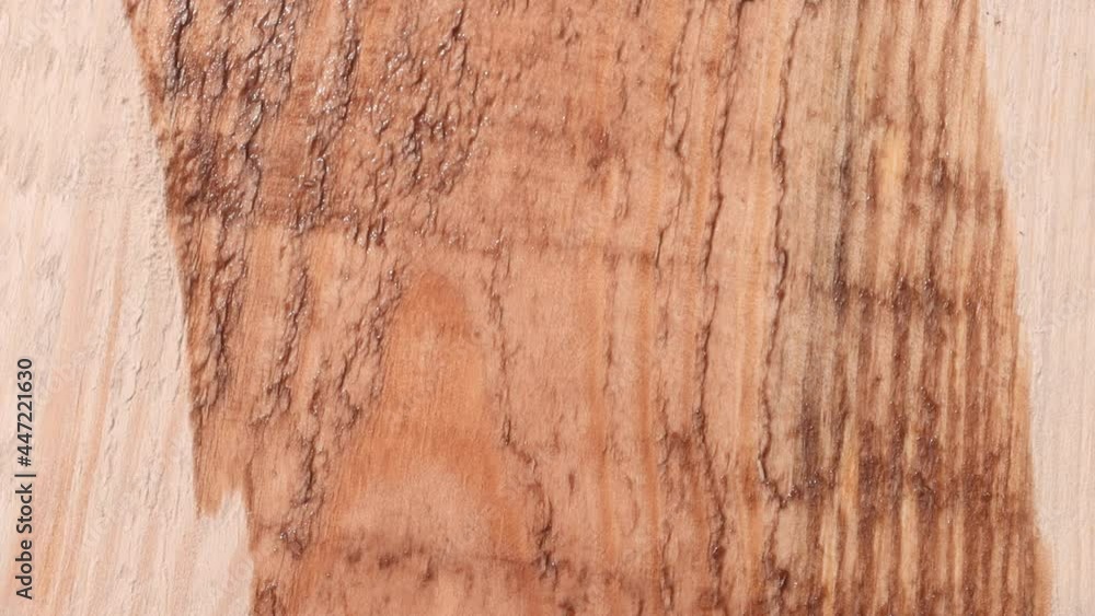 Close-up of applying a protective coating and paint to a wooden board. Wood texture. Painting the product with a brush. Close-up of applying a protective coating and paint to a wooden board. Wood texture. Painting the product with a brush.